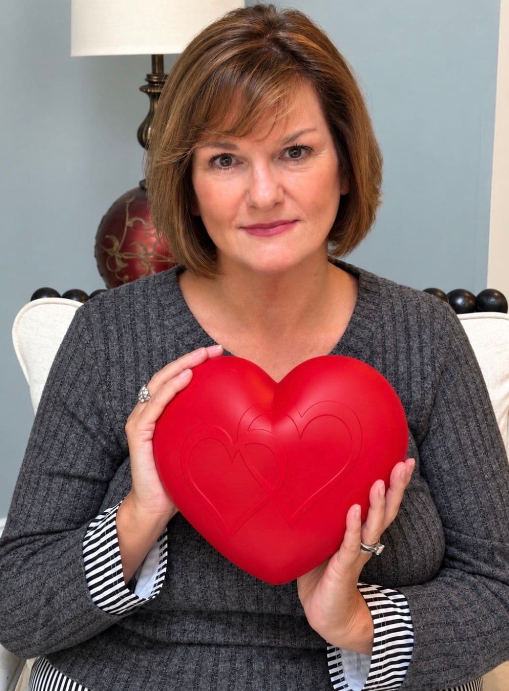 Deb holding the red silicone heart urn